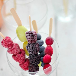 Frozen fruit in a skewer to cool down your drink.